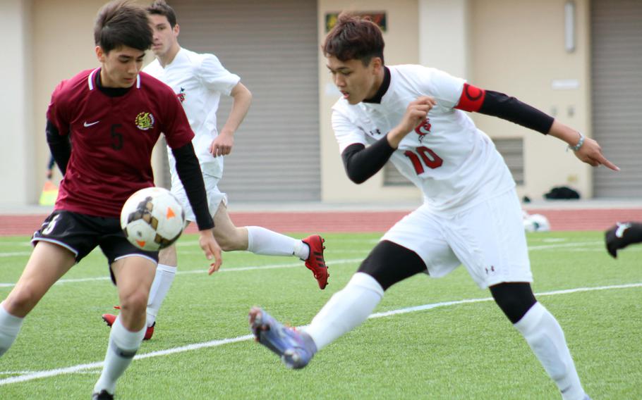 E.J. King’s Kyo Tominaga boots the ball against Matthew C. Perry’s John Shaver during Saturday’s DODEA-Japan soccer match. The Samurai won 3-1.