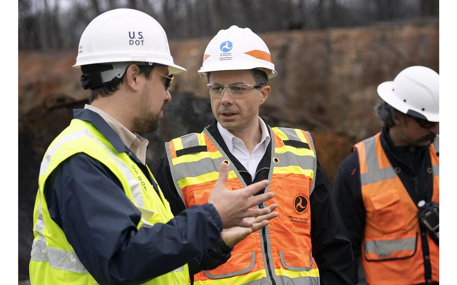 U.S. Secretary of Transportation Pete Buttigieg, center, visits with Department of Transportation Investigators on Feb. 23 2023, in East Palestine, Ohio, at the site of the Feb. 3 derailment of a Norfolk Southern Railways train carrying toxic chemicals.