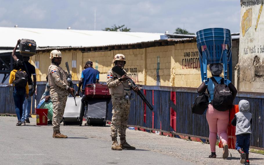 Dominican Republic security forces stand guard on a border bridge between Dajabón, Dominican Republic, and Haiti, Thursday, Sept. 14, 2023. The president of the Dominican Republic announced Thursday that he would close all borders with neighboring Haiti starting Friday in response to the construction of a supposed canal on Haitian soil that targets waters from the Massacre River, which runs along the border shared by both countries. 