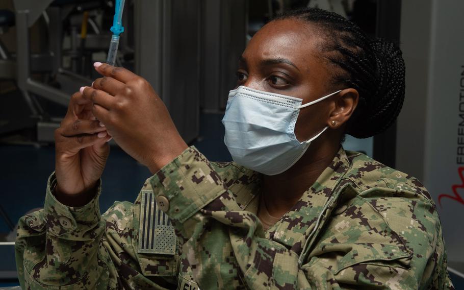 U.S. Navy Lt. Rochelle Bailey, from New York, draws up diluent for COVID-19 vaccine shots in Naval Station Norfolk, Va., March 11, 2021.