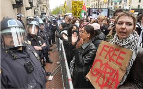 Police in Riot gear stand guard as demonstrators chant slogans outside the Columbia University campus in New York on April 18, 2024.