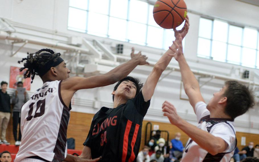 E.J. King's Nolan FitzGerald skies for a rebound between Matthew C. Perry's Shion Fleming and Jordan Wooten during Saturday's DODEA-Japan basketball game. The Cobras rallied from a 12-point third-quarter deficit to win 72-59.