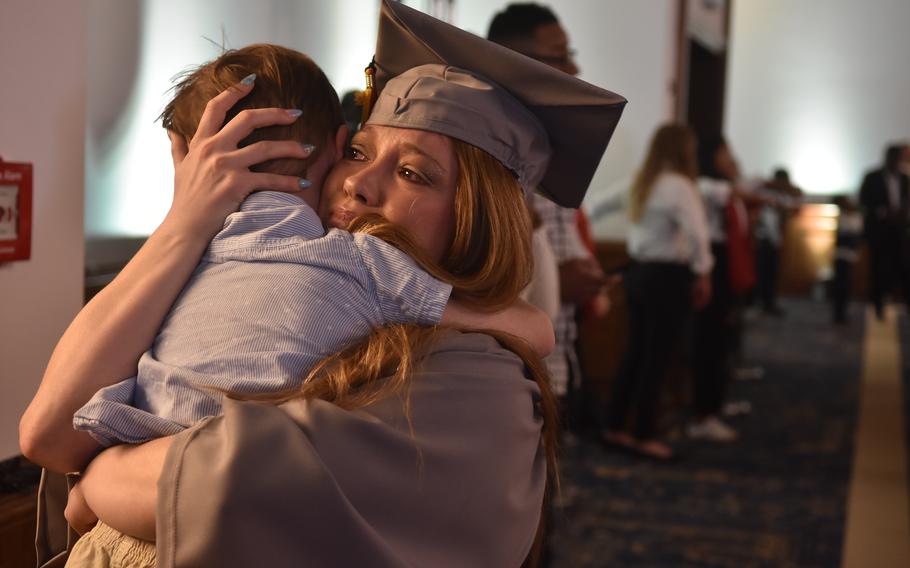 Marlee DaBrowski, an Army spouse, tearfully hugs her son, John, 4, after receiving her associate’s degree in general studies at the University of Maryland Global Campus Europe commencement ceremony on Saturday, April 27, 2024, at Ramstein Air Base, Germany. About 250 graduates walked the stage, out of a class of more than 1,100 who earned degrees from Europe, North Africa and the Middle East.