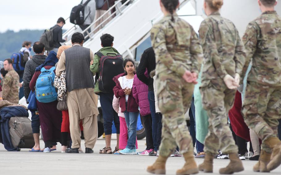 Evacuees from Afghanistan board a commercial flight going to the United States on Aug. 26, 2021, after a temporary stay at Ramstein Air Base, Germany. Health officials administered more than 12 measles, mumps and rubella vaccinations Thursday ahead of mass vaccinations scheduled to begin Friday at Ramstein and nearby Rhine Ordnance Barracks.