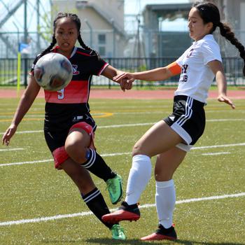 E.J. King's Katelyn Mapa and Matthew C. Perry's Towa Albsmeyer try to play the ball during Saturday's DODEA-Japan soccer match. The teams played to a scoreless draw, the Samurai's eighth tie of the season and the Cobras' ninth.
