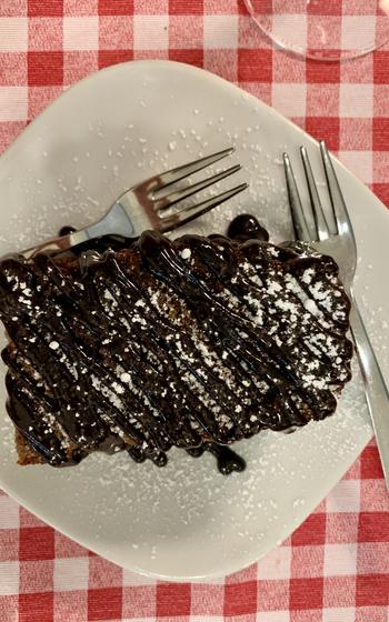 A serving of chocolate cake sits on a restaurant table.