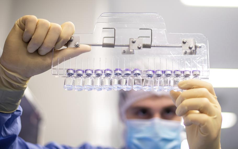 A technician inspects filled vials of the Pfizer-BioNTech COVID-19 vaccine at the company's facility in Puurs, Belgium, in March 2021.