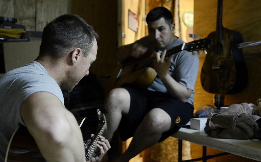 Spc. Lindsey Stolz, left, and Sgt. Robert Acosta frequently play their guitars together on Combat Outpost Sabari.