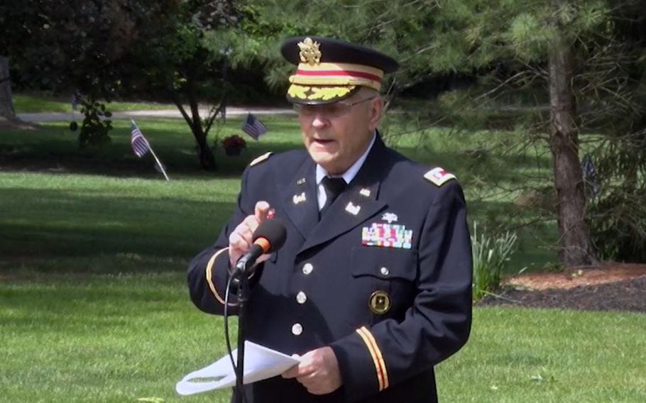 In this image captured from Hudson public access television, retired Army Lt. Col. Barnard Kemter checks to see if the microphone is functioning after organizers turned off audio during a portion of his Memorial Day speech Monday, May 31, in Hudson, Ohio.