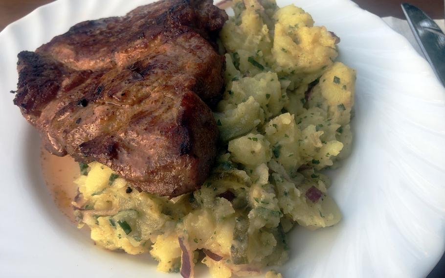 A pork neck steak with homemade potato salad as served at the Biergarten in Darmstadt, Germany. Both were delicious, but the potato salad, made with a dill vinaigrette dressing, was one of the best my wife and I have tasted at a restaurant.