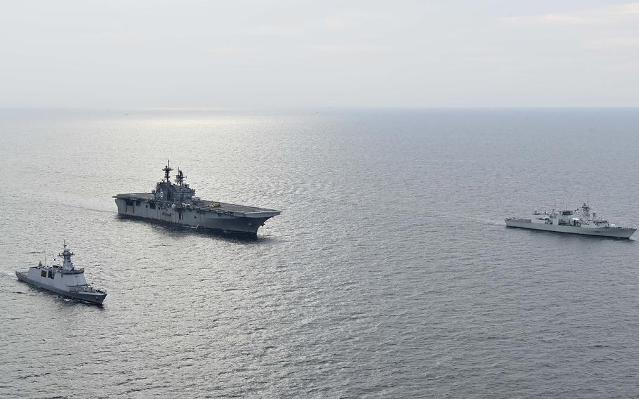 The amphibious assault ship USS America, center, the South Korean guided-missile frigate ROKS Seoul, left, and the Canadian frigate HMCS Vancouver train together in the Yellow Sea, Thursday, Sept. 14, 2023. 