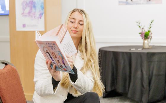 A woman reads a book in her hand