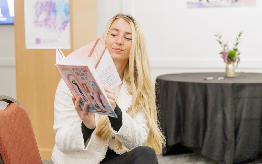 Riley Tejcek holds up a book as she reads to kids. 