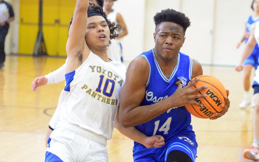 Osan's Jaylon Grant drives against Yokota's Royce Canta during Thursday's pool game in the 5th American School In Japan Kanto Classic basketeball tournament. The Panthers won 61-33.