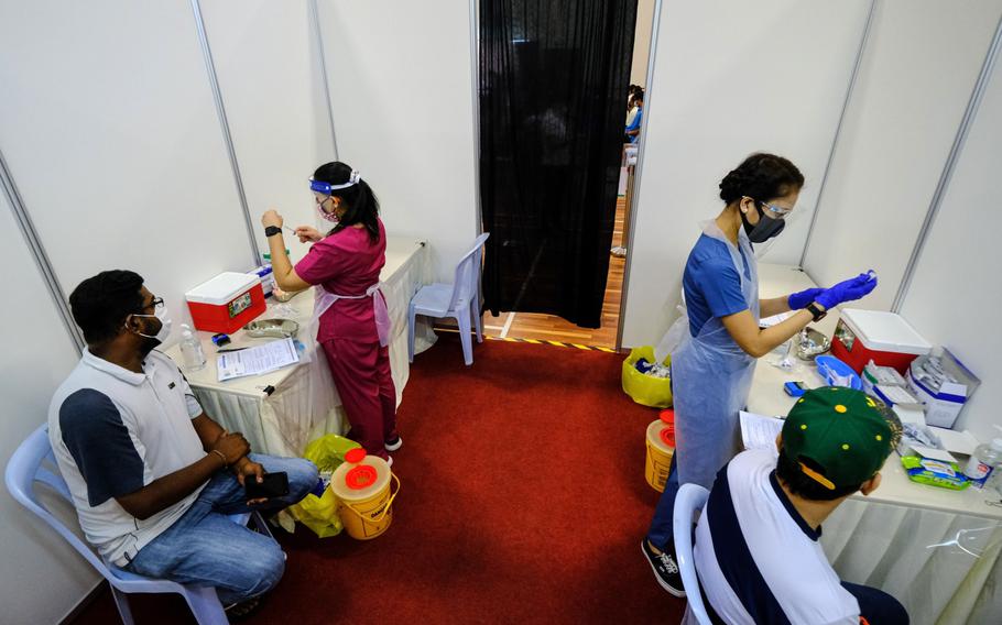 Health workers prepare doses of Covid-19 vaccine for sailors and port workers in Port Klang, Malaysia, on June 25.