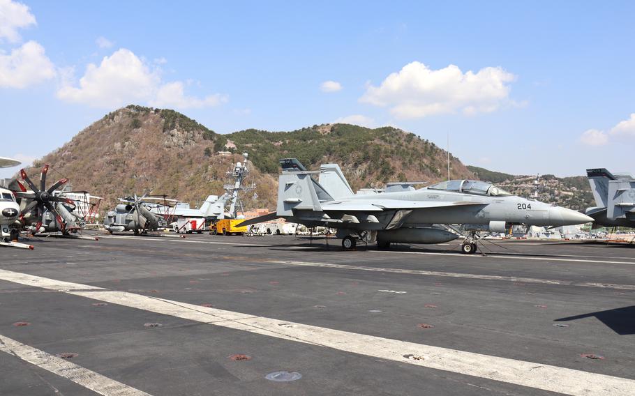 U.S. Navy F-18 Hornets, E-2C Hawkeyes and MH-60R Seahawks on the deck of the USS Nimitz in Busan, South Korea, March 28, 2023. 