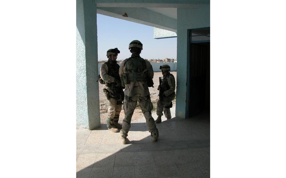 Leaders of 10th Mountain Division's Company C, 4th Battalion, 31st Infantry Regiment discuss how a rocket was buried inside the Saba al Boor police station gate in Iraq. 