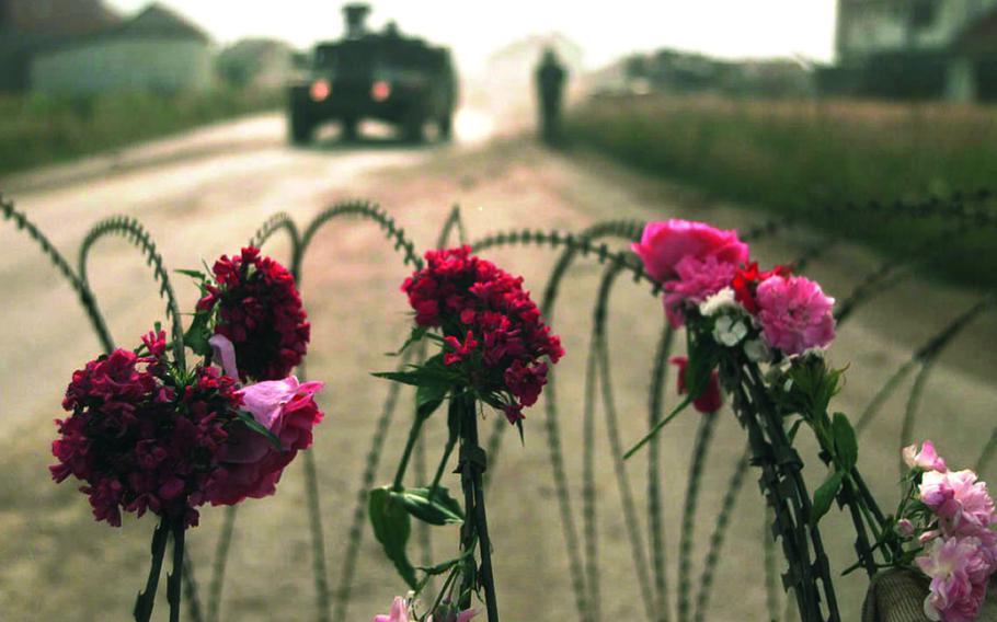 Flowers tied to concertina wire.