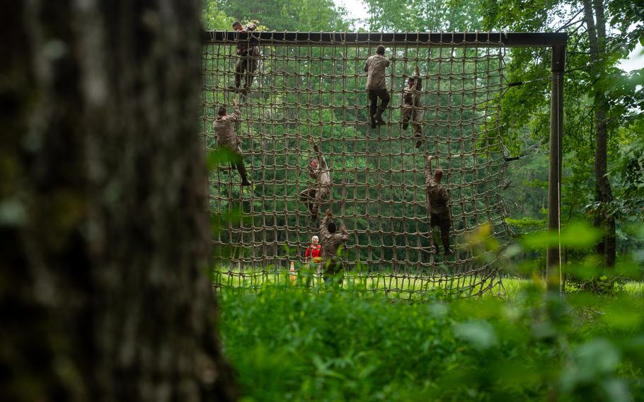 Marines climb a rope wall.