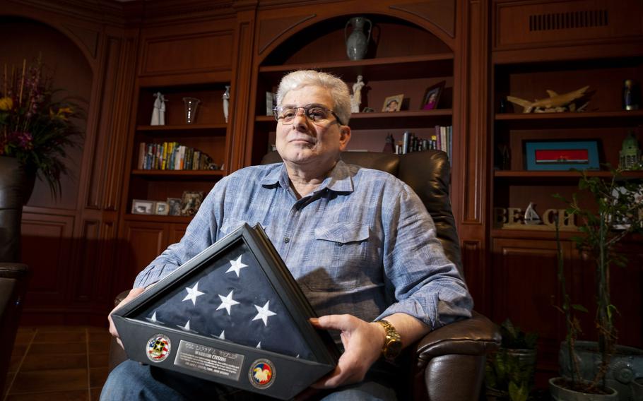 Larry Wexler stands for a portrait with an award he was given for his service at his residence in Virginia Beach, Va., on Dec. 8, 2022. Wexler is the author of the children’s book “Forest of Dreams,” and an Iraqi war veteran. Wexler served from 1978-2009 and retired as a colonel.