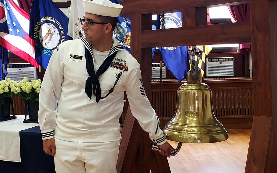 A sailor rings a ceremonial bell as the names of sailors who died in service over the past year are read aloud at Yokosuka Naval Base, Japan, Thursday, Sept. 22, 2022. 