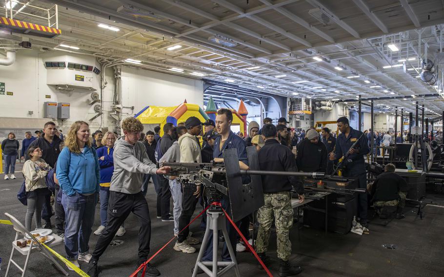 Sailors and guests tour spaces aboard the USS Abraham Lincoln