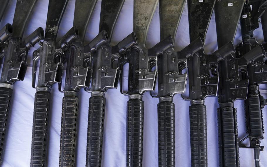 Guns on a table lined up in a row.