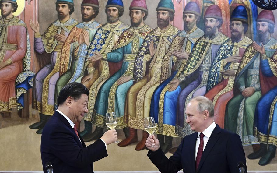 Russian President Vladimir Putin, right, and Chinese President Xi Jinping raise a toast at their dinne