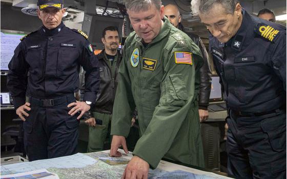 Vice Adm. Thomas Ishee, center, U.S. 6th Fleet commander, reviews a chart aboard the Italian navy aircraft carrier ITS Cavour in the Adriatic Sea on Feb. 24, 2023.