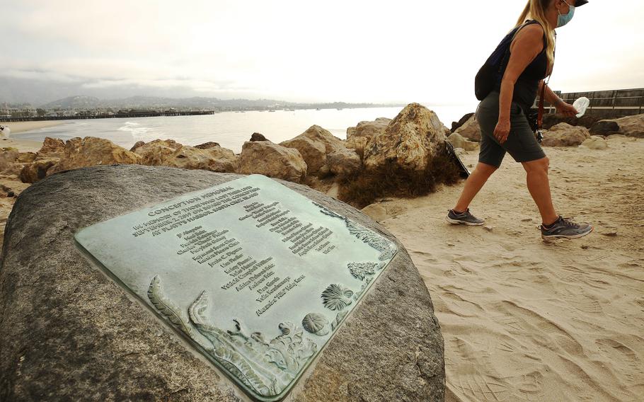 On the first anniversary of the 2019 Conception boat fire, Susan Tibbles walks past a memorial for the 34 people who died, in Santa Barbara, Calif. 