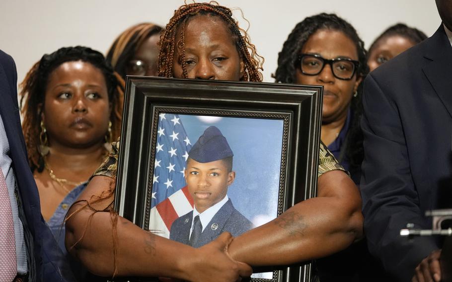 Senior Airman Roger Fortson’s family holding a picture of him.