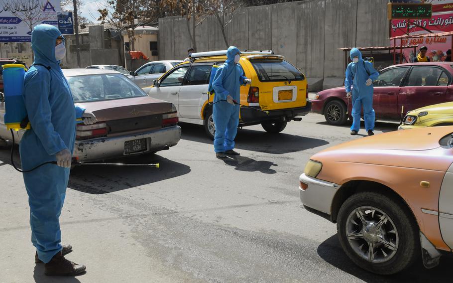 Workers in Kabul, Afghanistan, spray disinfectant to combat coronavirus in March 2020. The country is now suffering from a third wave of the pandemic. 