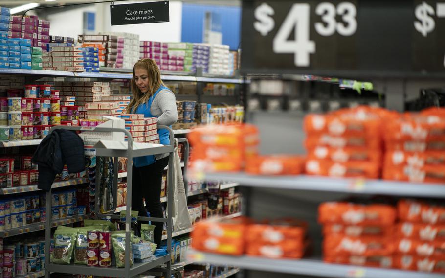 A worker organizes items at a Walmart Supercenter in North Bergen, N.J., on Feb. 9, 2023. The government said Tuesday, March 14, 2023, that prices increased 0.4% last month, just below January’s 0.5% rise.