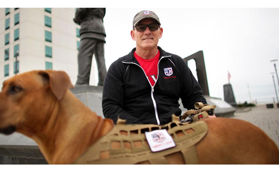 Michael Murray, founder of Liberty Organization for Veterans and Emergency Responders, a nonprofit that provides post-traumatic stress treatment to active duty service members, veterans and first responders, sits with his dog Stryder, at the Naval Aviation Monument Park along the Oceanfront, in Virginia Beach, Va., on Oct. 24, 2022.