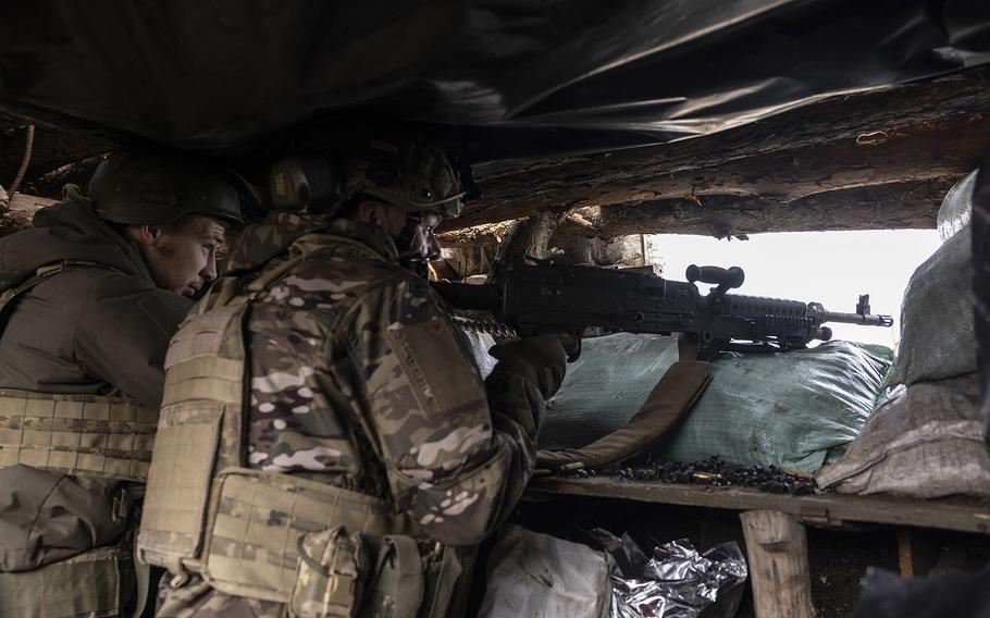 Ukrainian soldiers from the 24th Separate Mechanized Brigade use a U.S.-made M240 machine gun to shoot toward Russian positions from a trench near Niu-York. 