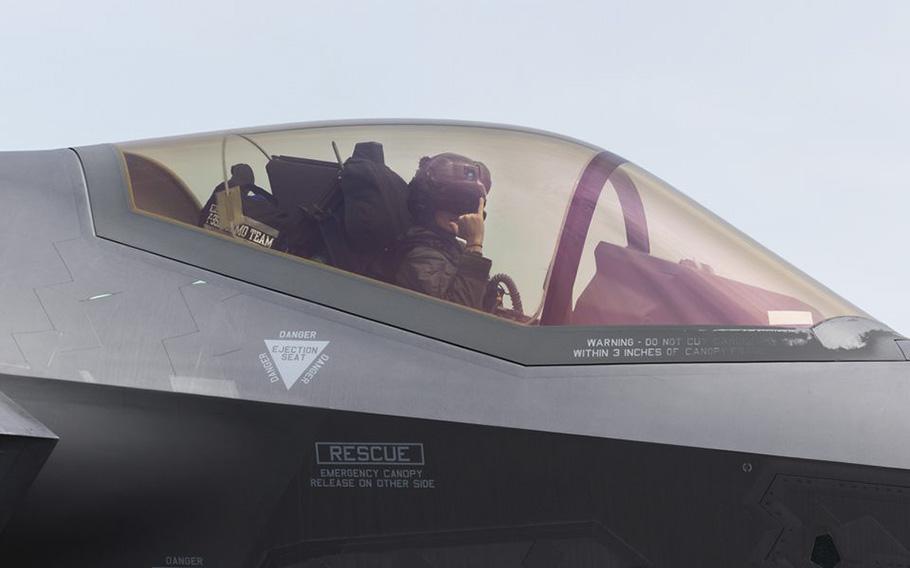 Maj. Kristin “BEO” Wolfe, the commander of the F-35A Lightning II Demonstration Team,  gives a hand signal while sitting in the cockpit of the fighter jet at Westfield Barnes Air National Guard Base on May 9, 2023. 