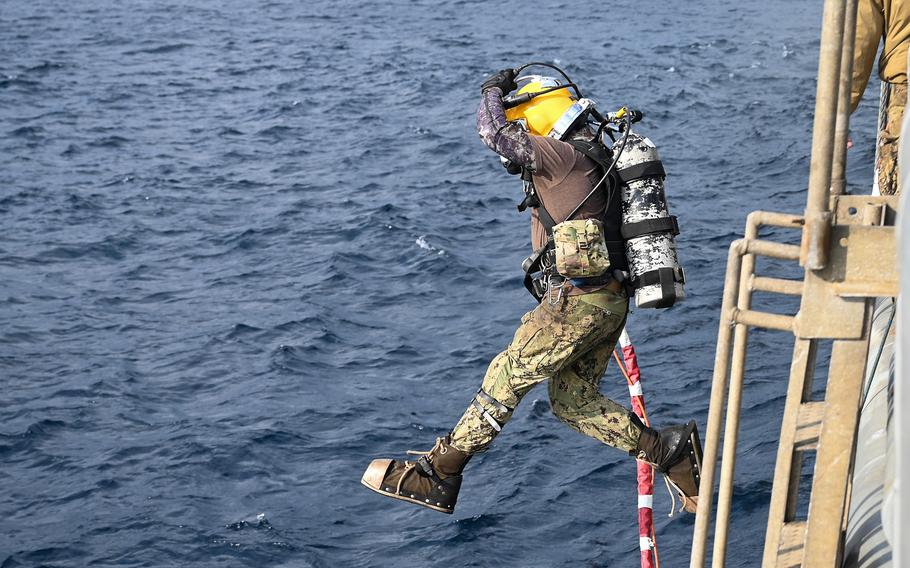  A U.S. Navy diver jumps from the USNS Salvor during the ongoing CV-22 Osprey recovery efforts off the coast of Yakushima, Japan, on Dec. 27, 2023. 
