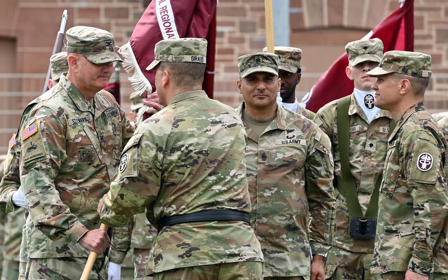 A flag is handed off between soldiers.