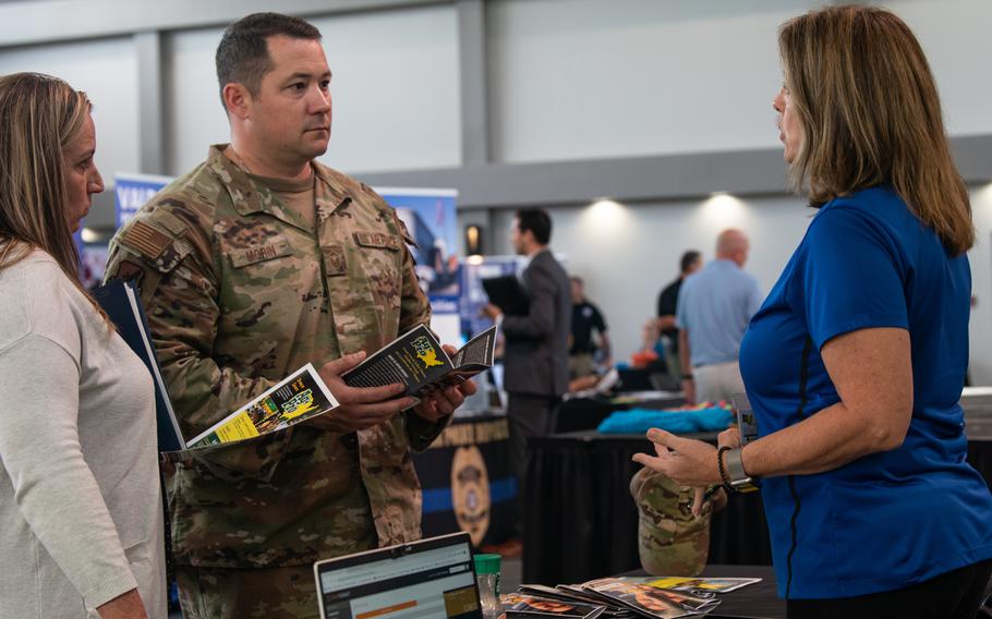 An Air Force couple discusses employment opportunities during a career fair at Moody Air Force Base in Georgia on Oct. 13, 2022. A new direct-hire program offered by the service aims to make it easier for qualified civilian spouses stationed overseas to find employment.