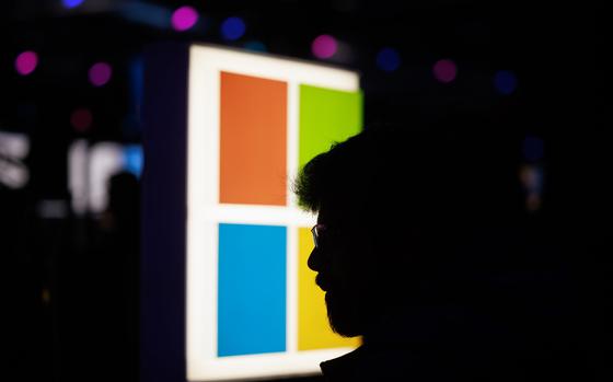 A face in shadow with the Microsoft logo in the background.