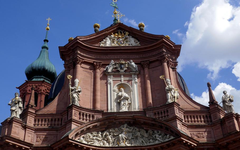 The ornate baroque facade of the Neumuenster basilica in Wuerzburg, Germany. 
