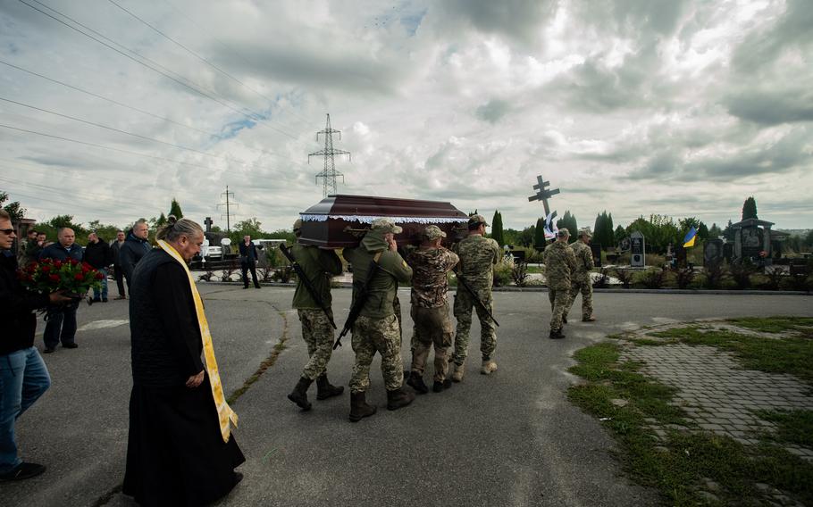 Ukrainian soldiers carry the casket of a fallen service member on their shoulders in Dnipro, Ukraine, Sept. 20, 2022.