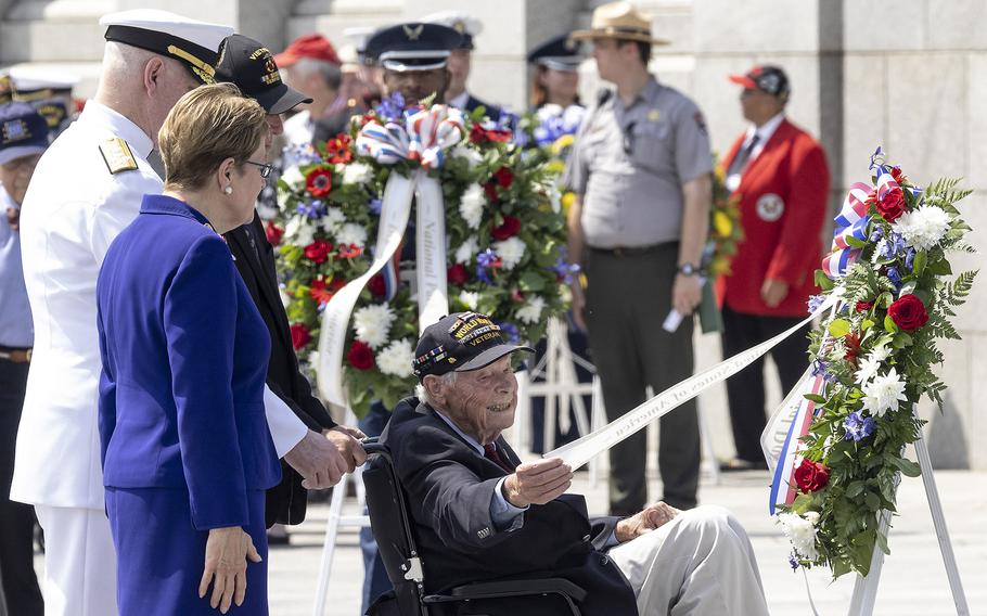 Veteran Les Jones reads theribbon on the wreathh he has just placed during the 20th anniversary celebration of the National World War II Memorial in Washington, May 25, 2024.