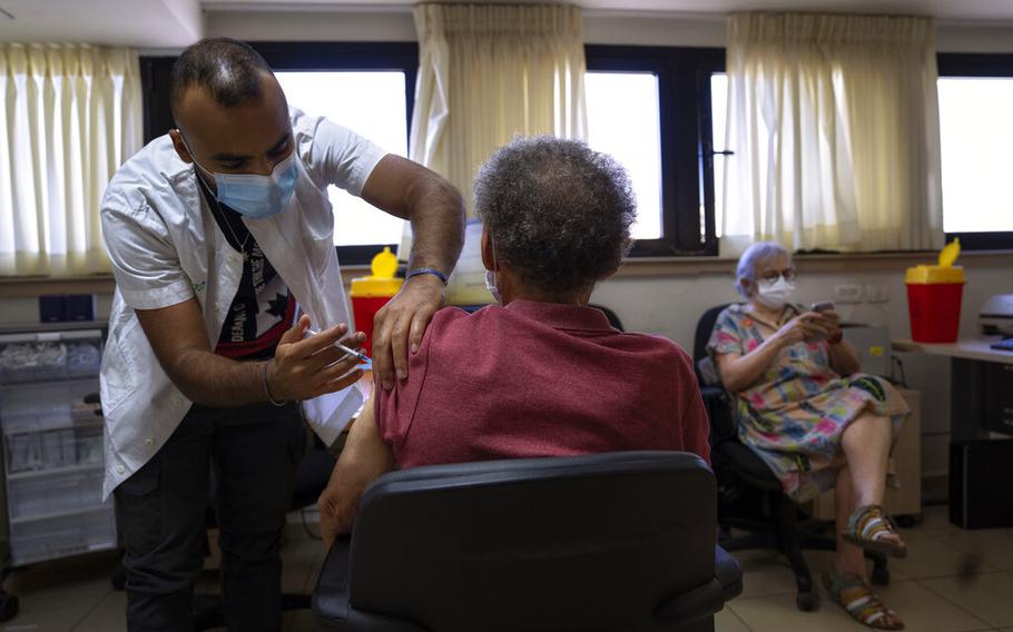 A man receives the fifth Pfizer-BioNTech COVID-19 vaccine from medical staff at Clalit Health services in Tel Aviv, Israel, Thursday, Sept. 22, 2022.