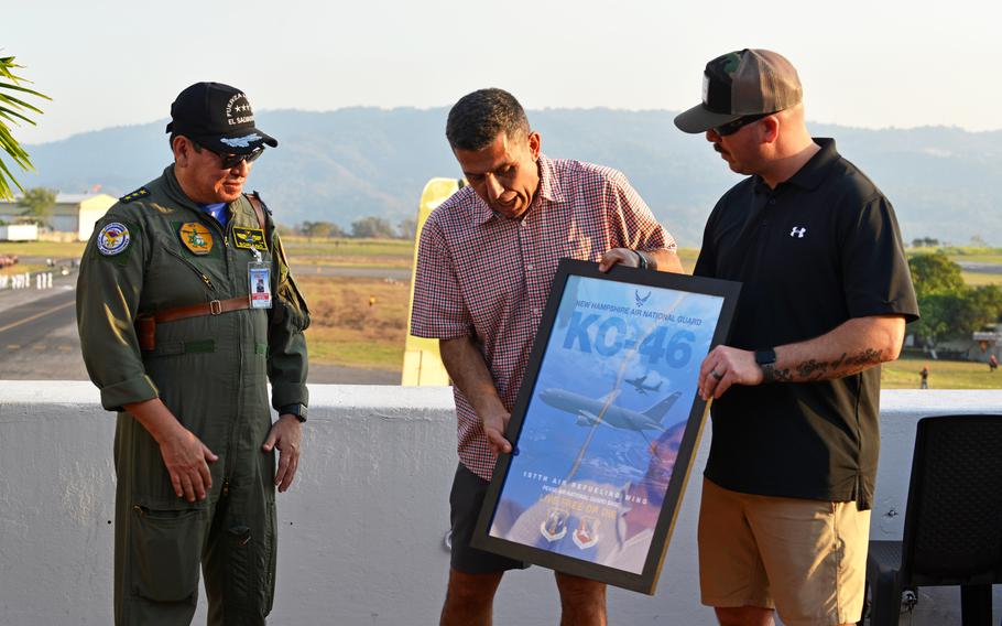 From right, 157th Air Refueling Wing Command Chief Master Sgt. Kevin Reither and Maj. Gen. David Mikolaities, New Hampshire adjutant general, present Col. Pablo Soriano, chief of the Salvadoran Air Force, a framed print of a KC-46 aircraft Feb. 17, 2024, at the Ilopango Air Show in El Salvador.