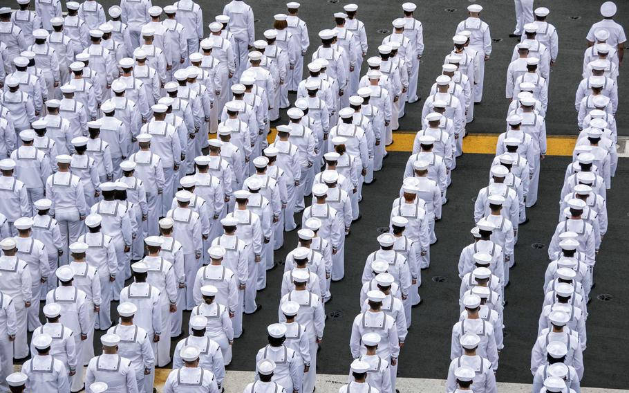 Sailors prepare to man the rails aboard the aircraft carrier USS Ronald Reagan as it departs Yokosuka Naval Base, Japan, Wednesday, May 19, 2021.