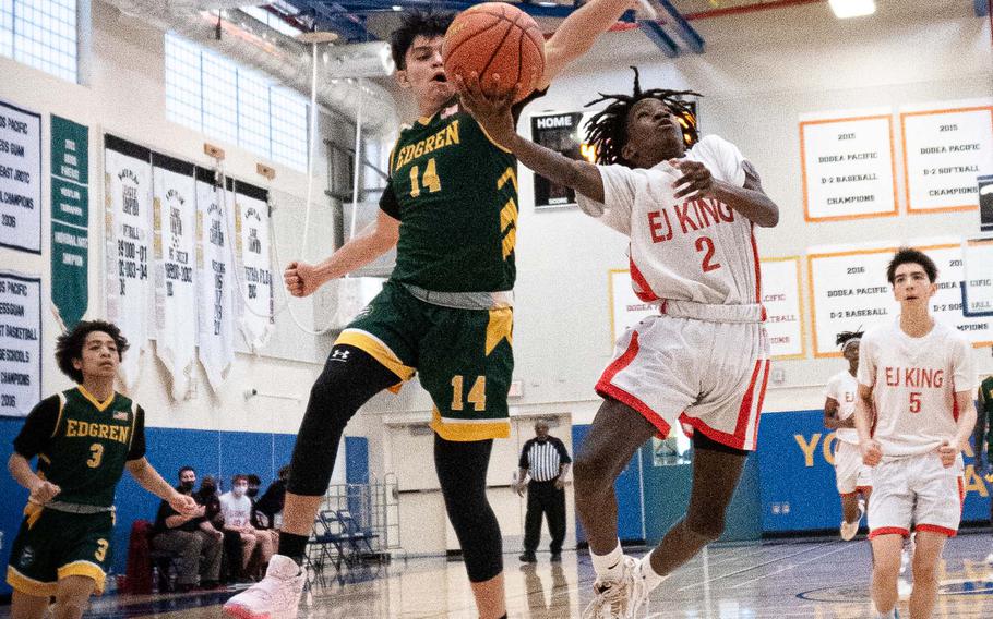 E.J. King's Jeremy Phillips drives to the basket against Robert D. Edgren's Dennis Nelson during Friday's DODEA-Japan boys basketball tournament. The Cobras won 74-28.