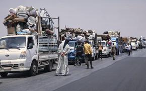 Trucks carrying around 60 displaced families gather on the highway as they head to their village, Kafr Sijna, after more than five years in the Atmeh camps near the Syrian-Turkish border, on a highway north of Kafr Sijna, Syria, Sunday, May 18, 2025. (AP Photo/Ghaith Alsayed)