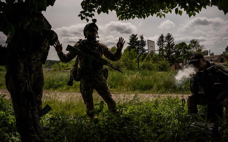 Members of the Kraken unit hide under trees while a Russian drone flies overhead.