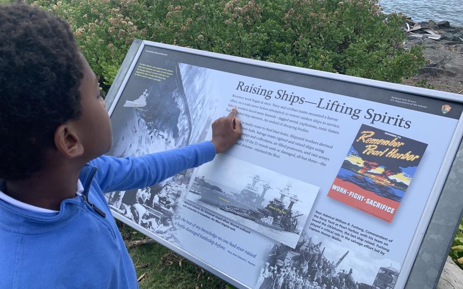 Harrison Johnson reads a sign at the Pearl Harbor National Memorial. 